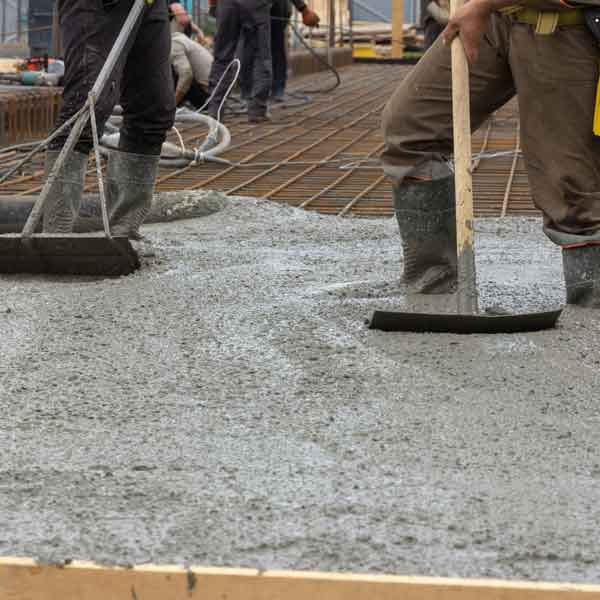 Workers pouring and spreading concrete